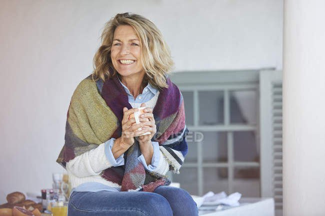 Enthusiastic senior woman drinking coffee on patio — Stock Photo
