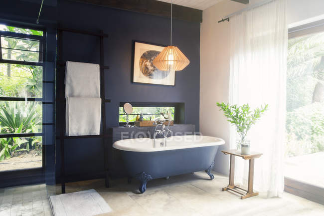 Bathtub and light fixture in modern bathroom — Stock Photo