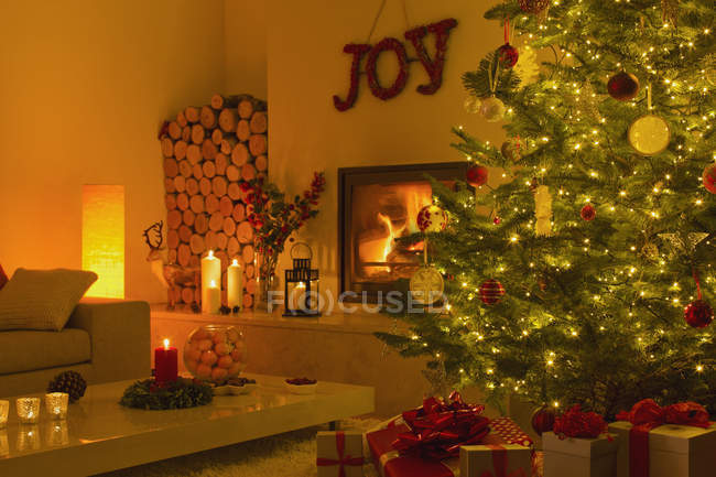 Ambient fireplace and candles in living room with Christmas tree — Stock Photo