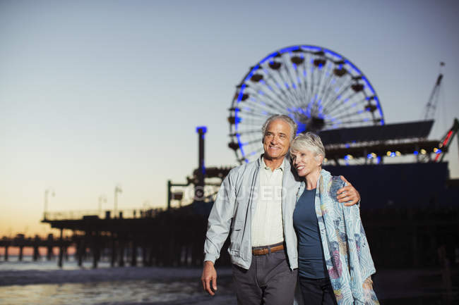Senior couple walking on beach at night — Stock Photo