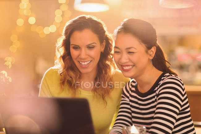 Усміхнені жінки друзі використовують ноутбук — стокове фото