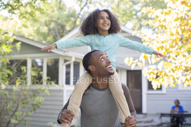 Батько, що носить щасливу дочку на плечах — стокове фото