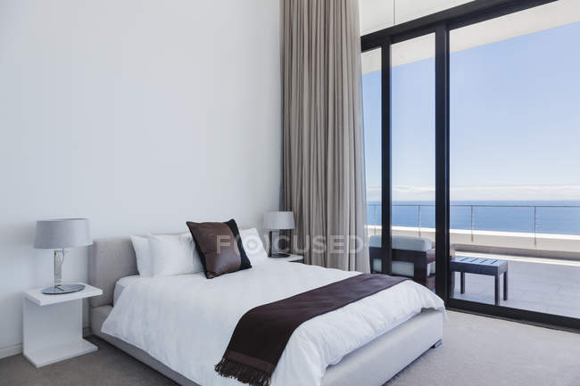 Letto e lampade in camera da letto moderna con vista sull'oceano — Foto stock
