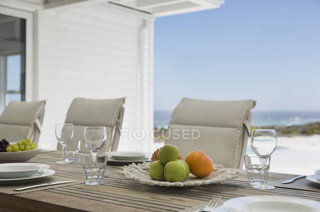 Fruits on plate against chairs near table at luxury modern house — Stock Photo