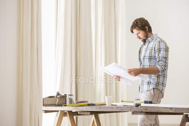 Hombre mirando a través de documentos - foto de stock