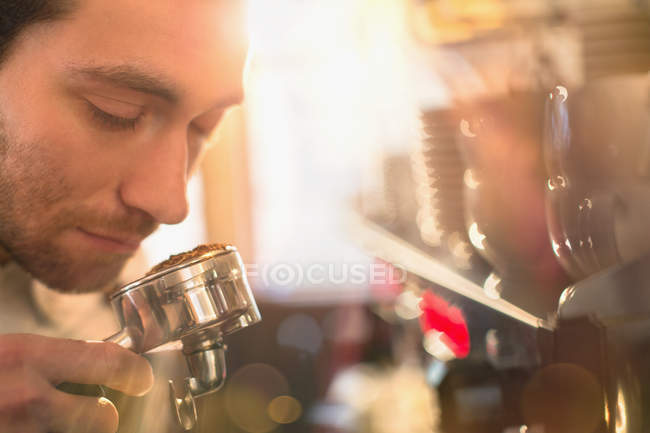 Close up barista smelling espresso grounds at espresso machine — Stock Photo