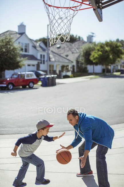 Padre e hijo jugando baloncesto en la entrada - foto de stock