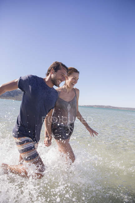 Couple splashing in water together — Stock Photo