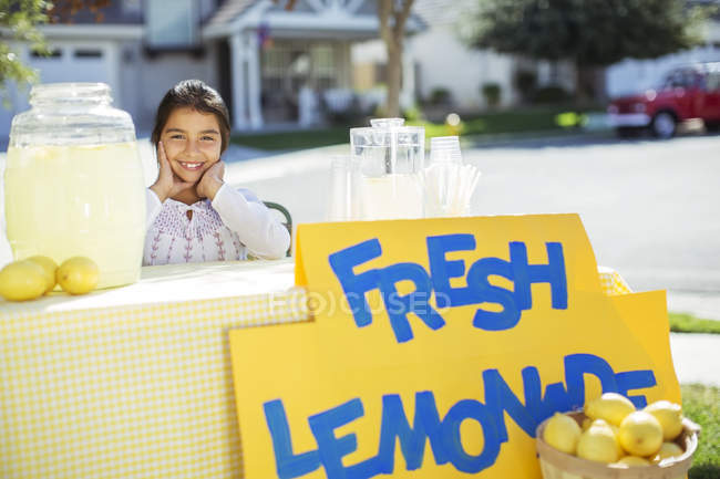 Портрет улыбающейся девушки на стенде с лимонадом — стоковое фото
