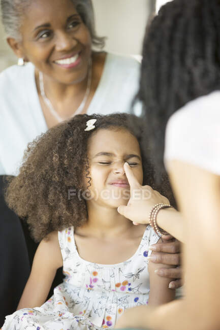 Madre giocosamente toccando figlia? naso s — Foto stock