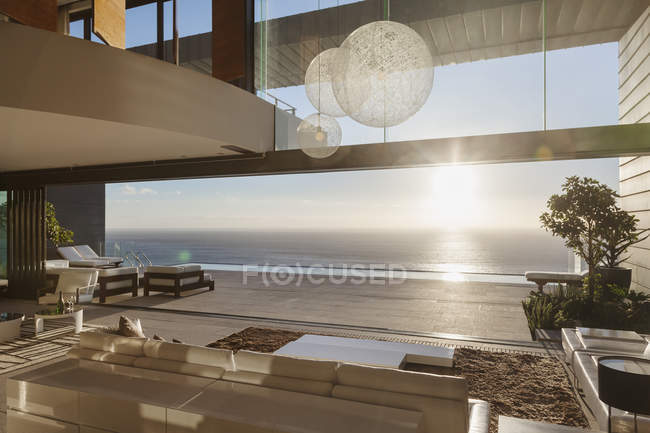 Современная гостиная с видом на океан на закате — стоковое фото