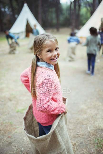 Menina sorrindo em saco no parque de campismo — Fotografia de Stock