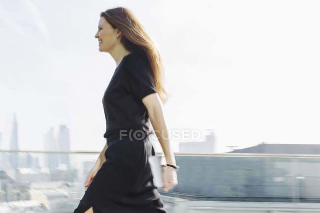 Businesswoman on the move on urban balcony — Stock Photo