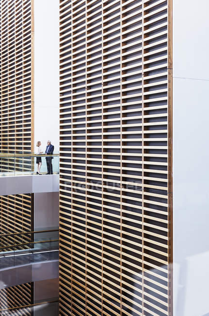 Empresários falando sobre passarela no moderno átrio de escritórios — Fotografia de Stock