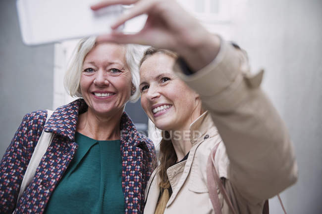 Sorridente madre e figlia prendere selfie con fotocamera telefono — Foto stock