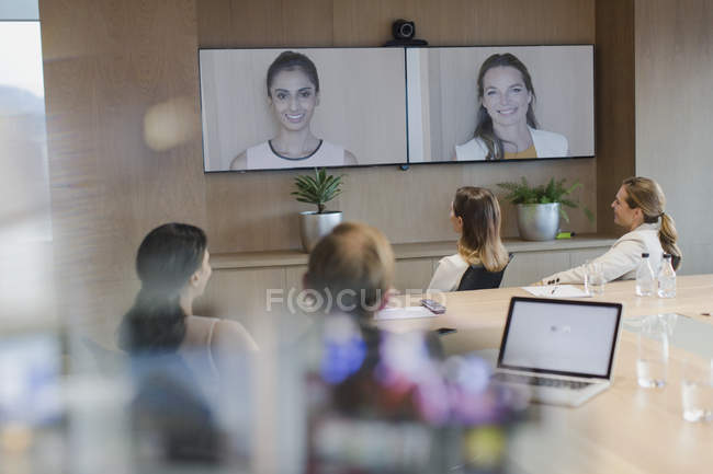 Деловые люди разговаривают на мониторах на видеоконференции — стоковое фото