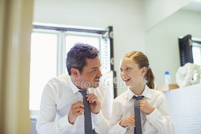 Father and daughter tying ties in bathroom — Stock Photo