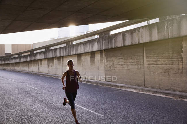 Corredor hembra corriendo en túnel urbano - foto de stock