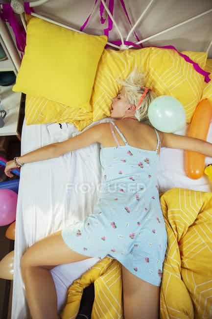 Blonde woman sleeping on bed after party — Stock Photo