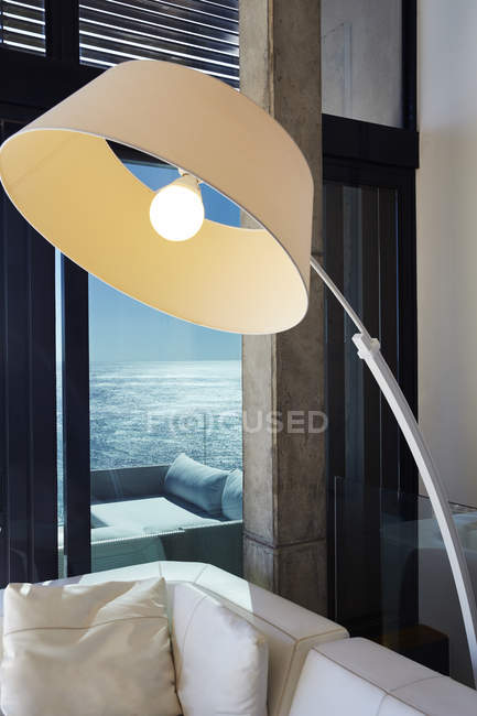 Лампа над диваном в роскошном современном доме — стоковое фото