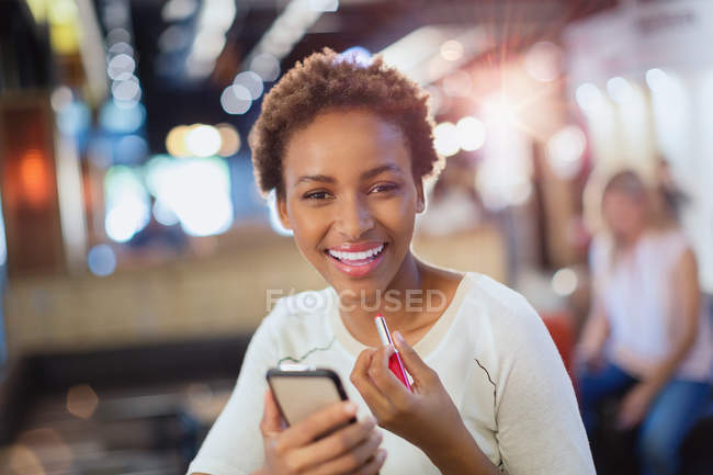 Ritratto sorridente giovane donna che applica il rossetto — Foto stock