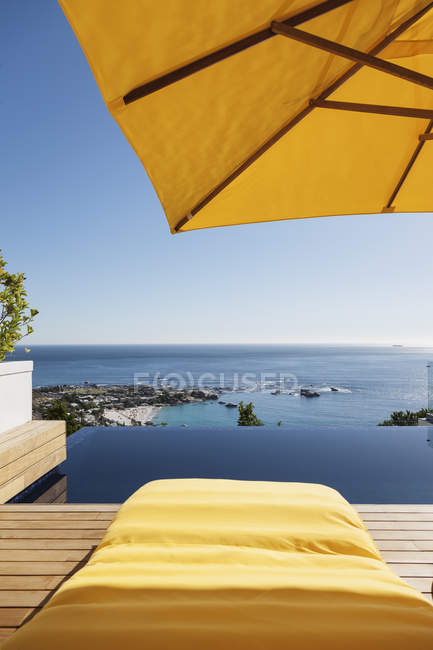 Lounge chair overlooking infinity pool and ocean — Stock Photo