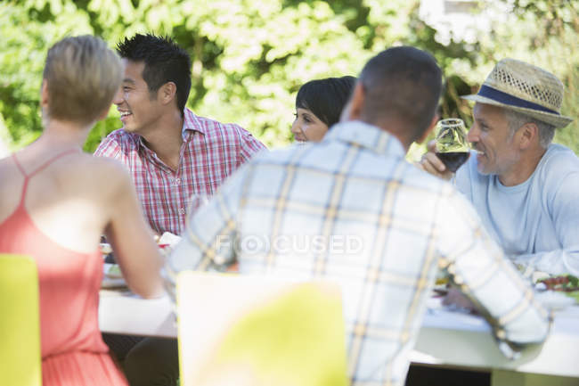 Friends relaxing at table outdoors — Stock Photo