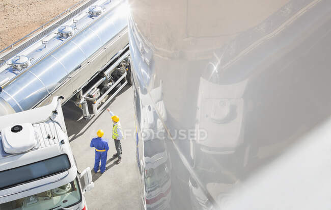 Workers talking next to stainless steel milk tanker — Stock Photo