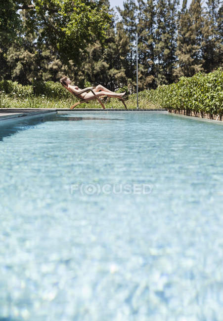 Mulher relaxando na piscina durante o dia — Fotografia de Stock