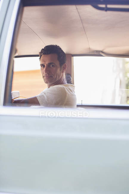 Feliz hombre moderno conduciendo coche en día soleado - foto de stock