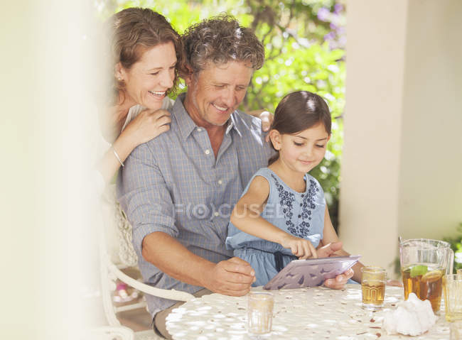 Grandparents playing on digital tablet with granddaughter — Stock Photo