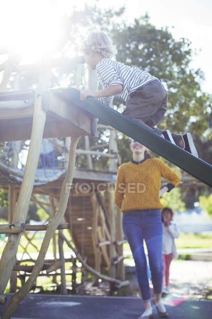 Teacher watching student play on play structure — Stock Photo