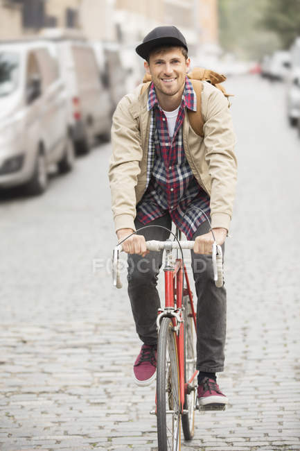 Hombre montar en bicicleta en la calle de la ciudad - foto de stock