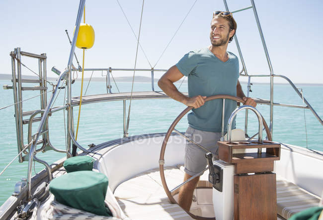 Mann steuert Segelboot auf dem Wasser — Stockfoto