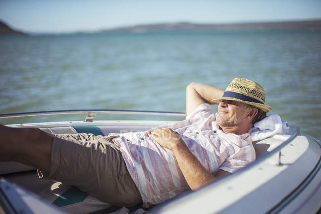Older man relaxing in boat on water — Stock Photo
