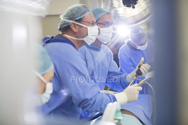 Medici che eseguono interventi chirurgici in sala operatoria — Foto stock