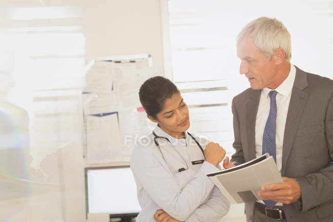 Médecin féminin et administrateur d'hôpital masculin examinant la paperasserie — Photo de stock