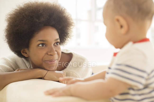 Mother and baby boy playing on sofa at home — Stock Photo
