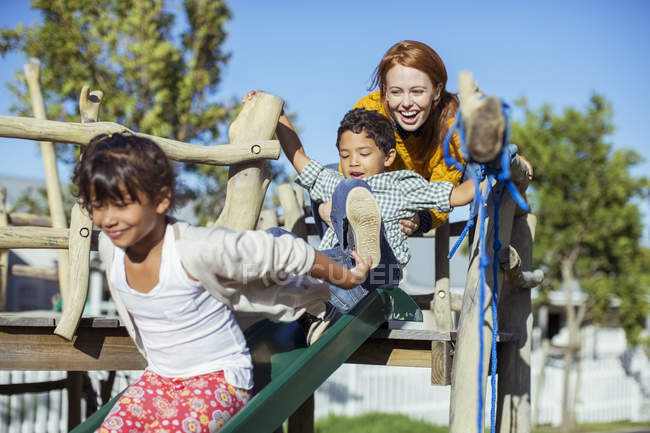 Professora e alunos brincando no playground — Fotografia de Stock