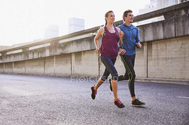 Runner coppia in esecuzione su strada urbana — Foto stock