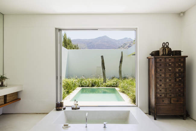 Salle de bain moderne avec vue sur la piscine de luxe — Photo de stock