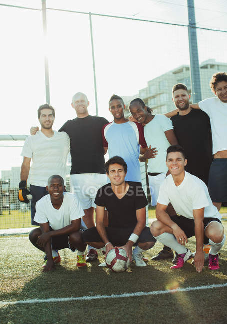 Group of amateur soccer players smiling on field — Stock Photo