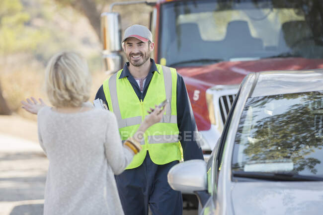 Woman greeting roadside mechanic — Stock Photo