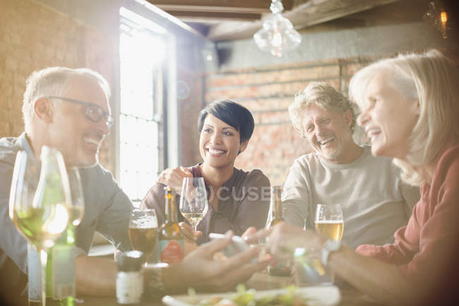 Couples dining and using cell phone at restaurant table — Stock Photo