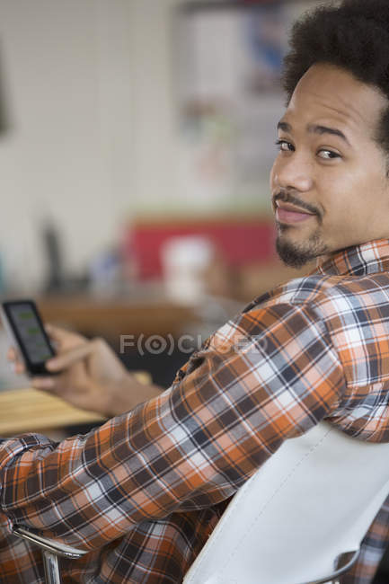 Portrait of confident man text messaging with cell phone — Stock Photo