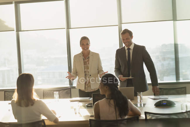 Улыбающиеся бизнесмены разговаривают в солнечном конференц-зале — стоковое фото