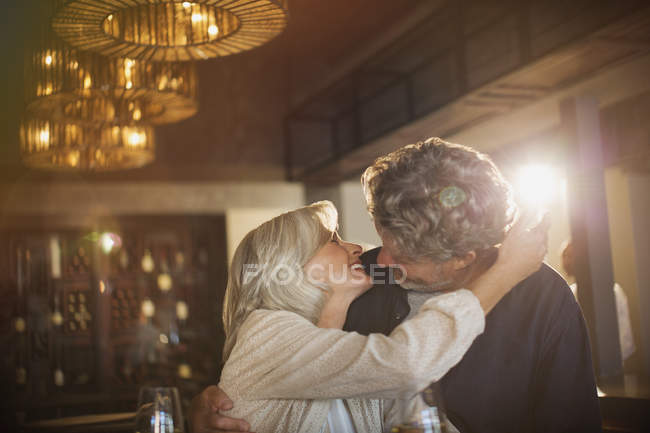 Casal sênior abraçando e beijando no bar — Fotografia de Stock