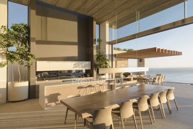 Soleado moderno, casa de lujo escaparate mesa de comedor interior con vista al mar - foto de stock