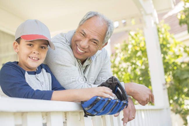 Grandfather and grandson with baseball glove on porch — Stock Photo