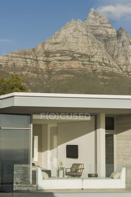 Soleado casa moderna escaparate balcón debajo de las montañas - foto de stock